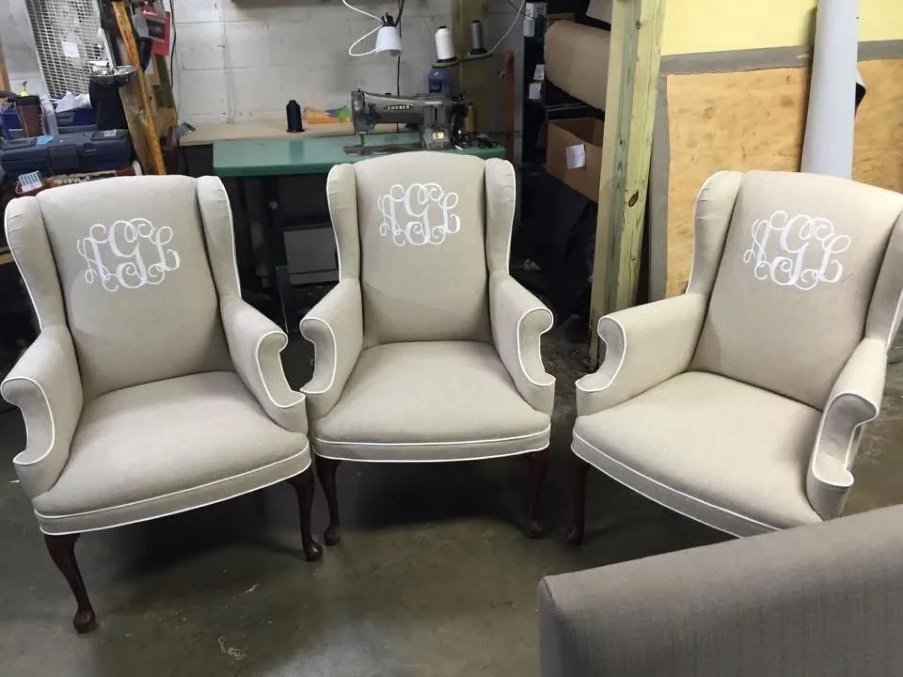 Monogrammed chairs beside a sewing machine in the Oak City workroom